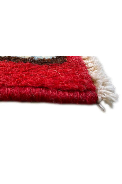Close-up of a Kerman carpet edge with red pile and fringes