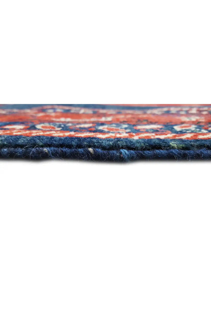 Carpet detail: deep-blue pile edge with a multicolored patterned stripe in red and blue