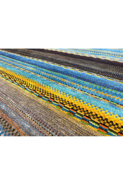 Close-up: Gabbeh rug fabric with colorful stripes in blue, yellow, and brown.