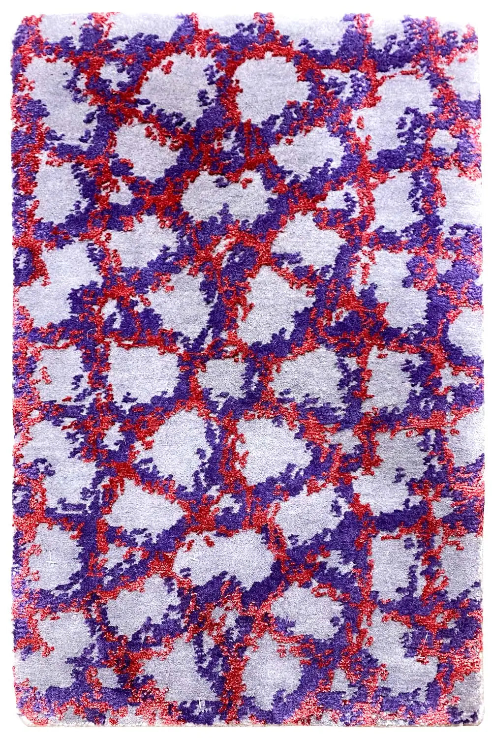 Rectangular rug with an abstract pattern in blue, red, and purple on a light background.