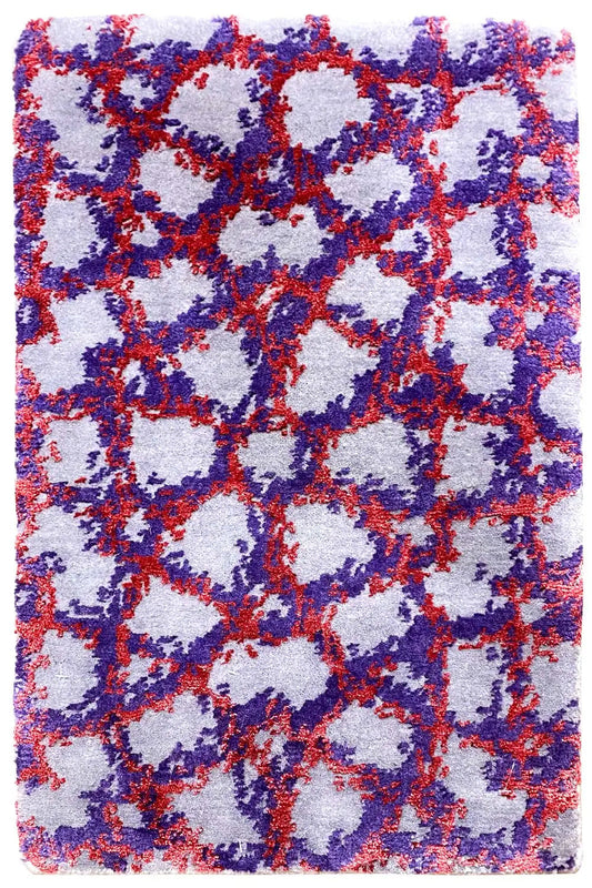 Rectangular rug with an abstract pattern in blue, red, and purple on a light background.