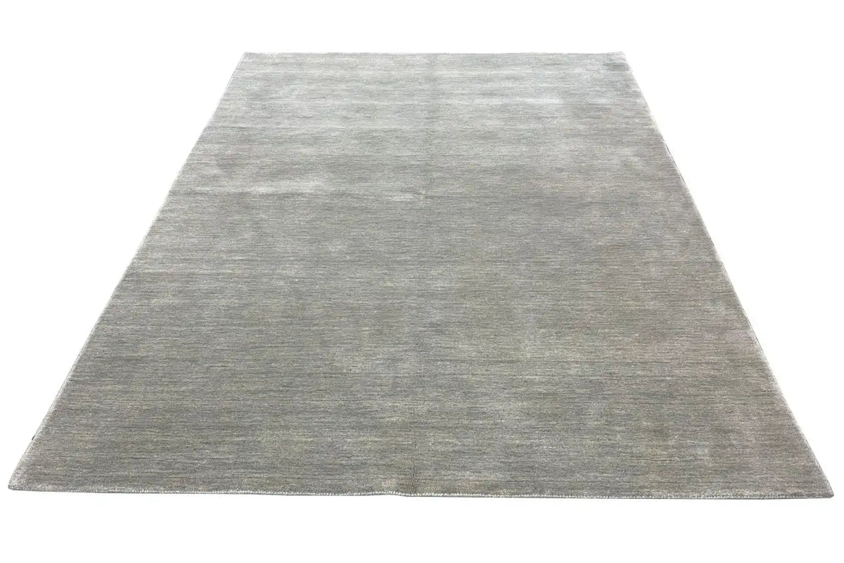 Light gray rectangular rug with a dense pile surface and straight edge