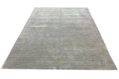 Light gray rectangular rug with a dense pile surface and straight edge