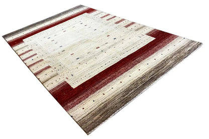 Gabbeh rug in cream and red with clearly defined zones and fine, scattered patterns