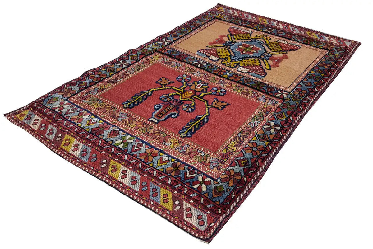 Flat-lying oriental rug with a red background, two ornamental panels, and a colorful border, 135x83 cm