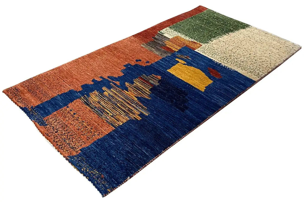 Gabbeh rug at an angle, geometric bars in blue, orange, and beige