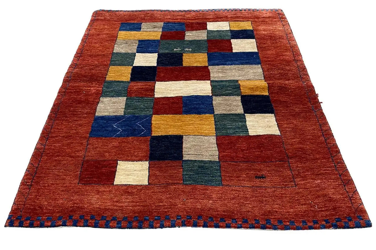 Lori gabbeh rug: red with multicolored squares and blue decorative stitching along the edge