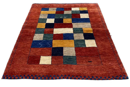 Lori gabbeh rug: red with multicolored squares and blue decorative stitching along the edge
