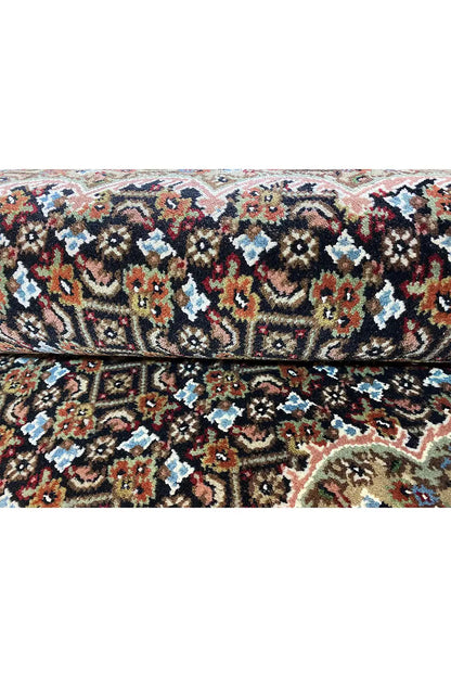 Carpet surface with a detailed pattern in black, red, blue, beige and green