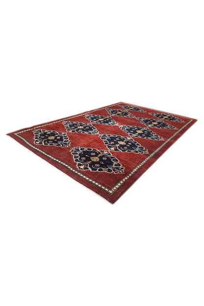 Rectangular rug with a red base and navy blue patterns accented in yellow