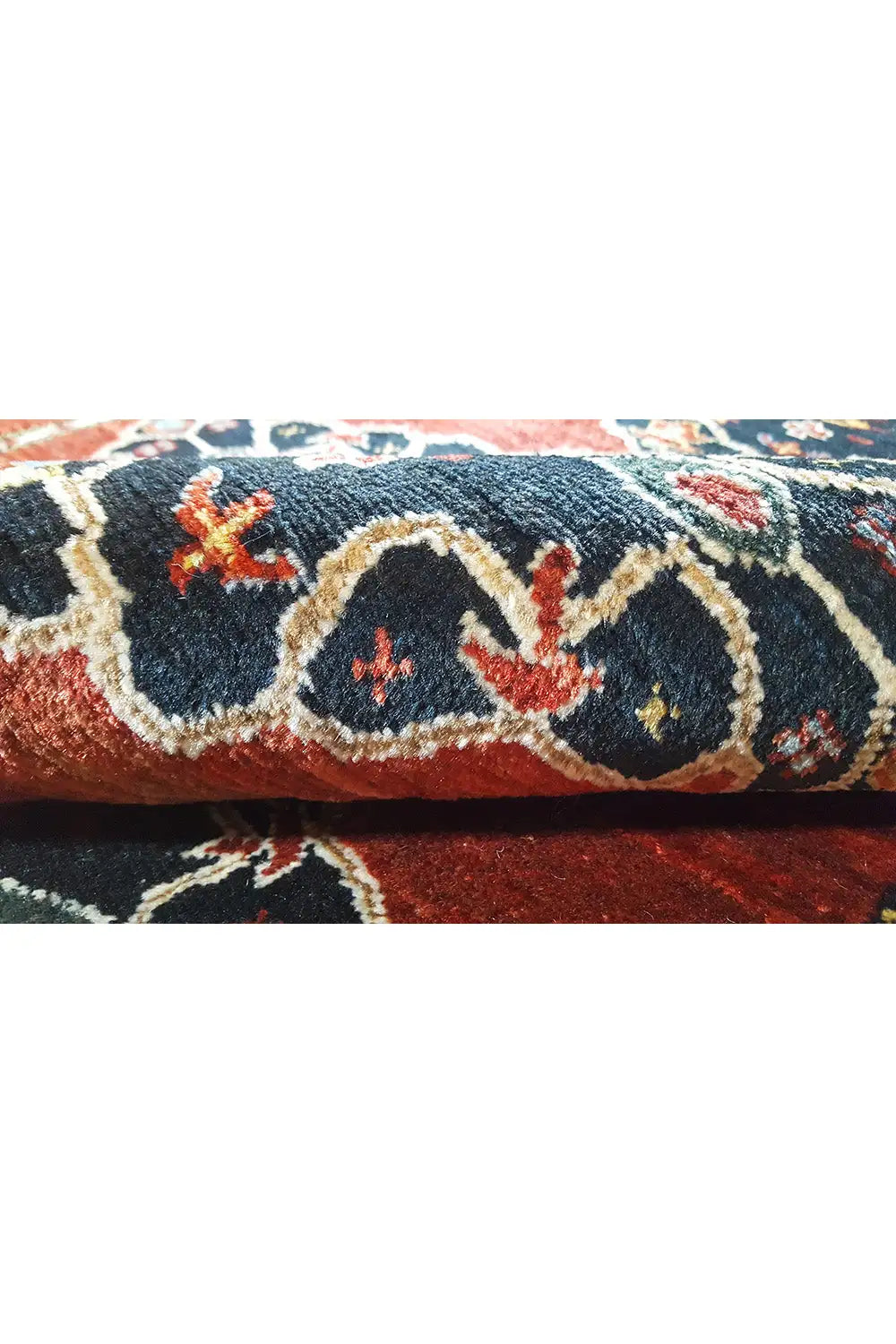 Close-up: woven carpet end with a blue pattern on a red background