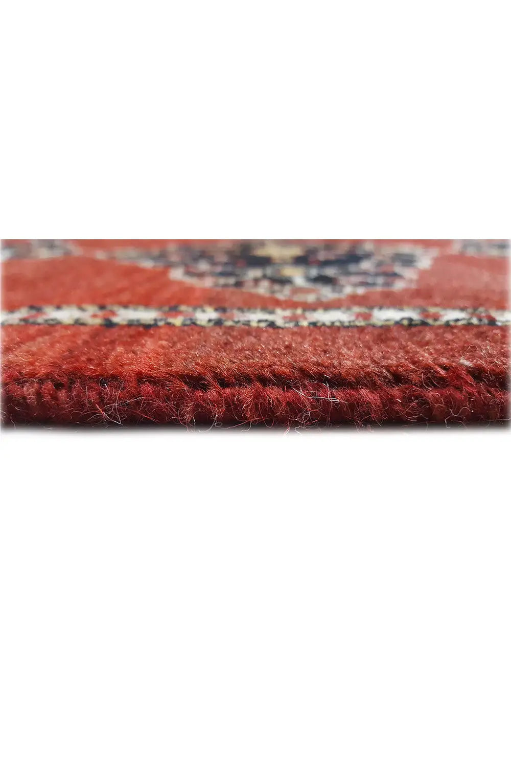 Close-up of the carpet edge with dense pile on a red background