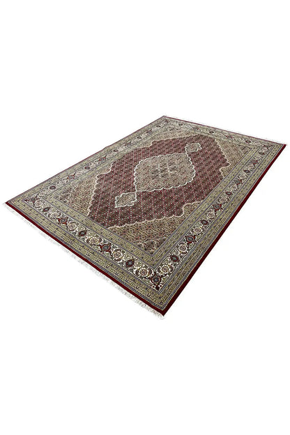 Tabriz rug, angled: dark red-brown field with beige medallion and ornaments