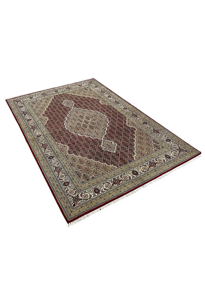 Tabriz rug, angled: red center with a beige ornamental field and dark border
