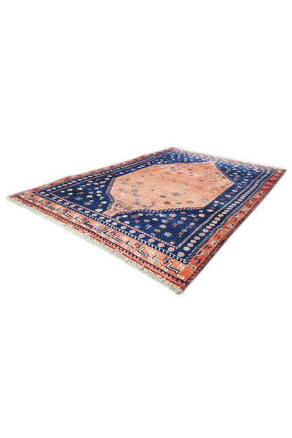Oriental rug corner view with a blue field, orange medallion, and borders