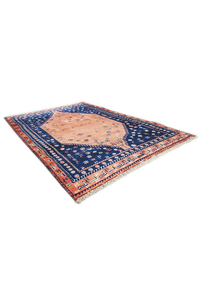 Oriental rug corner view with blue border, orange central medallion, and patterned border