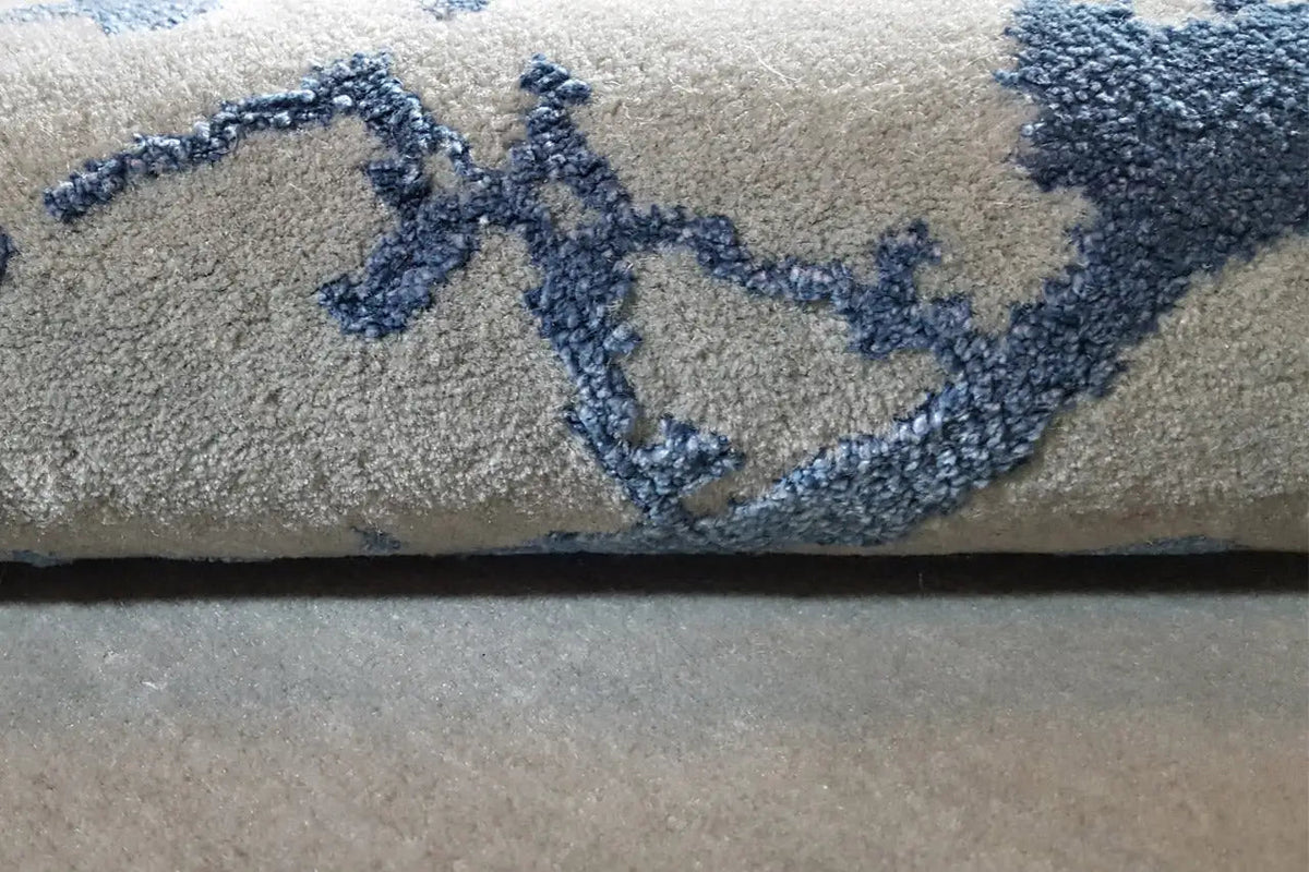Close-up: gray carpet pile with a blue ink line and clearly visible texture.