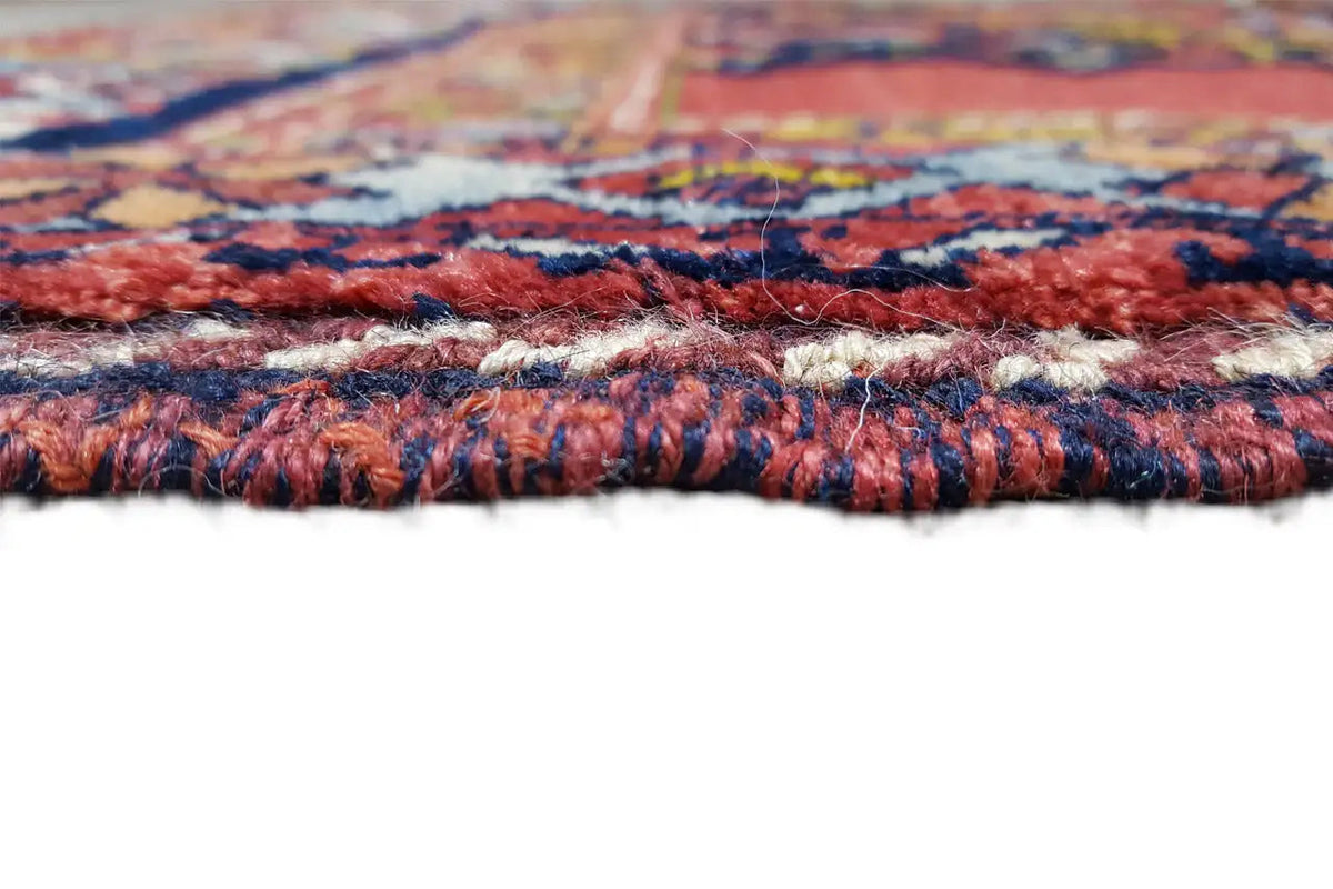 Detailed view of the carpet edge with a multicolored woven pattern and fringed border tassels
