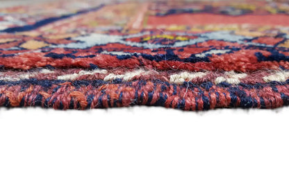 Detailed view of the carpet edge with a multicolored woven pattern and fringed border tassels
