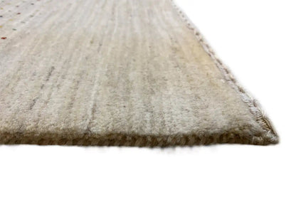 Gabbeh rug, close-up with fringed edge and beige pile with colored specks