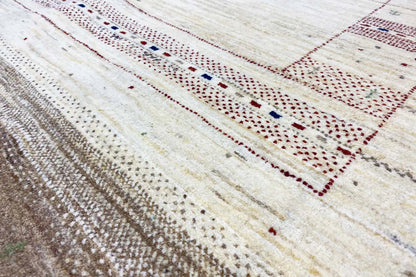 Lori Gabbeh rug detail: fine decorative border with red and blue dots on a light beige background