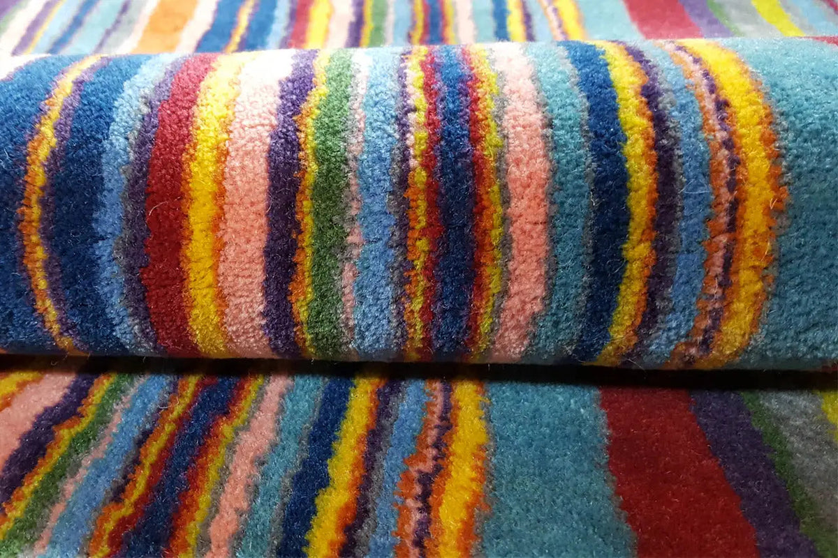 Carpet detail: blue pile with a dense, multicolored stripe gradient