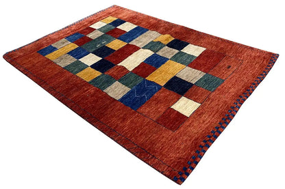 Red Lori Gabbeh rug with a checked pattern in blue, green, yellow, and white