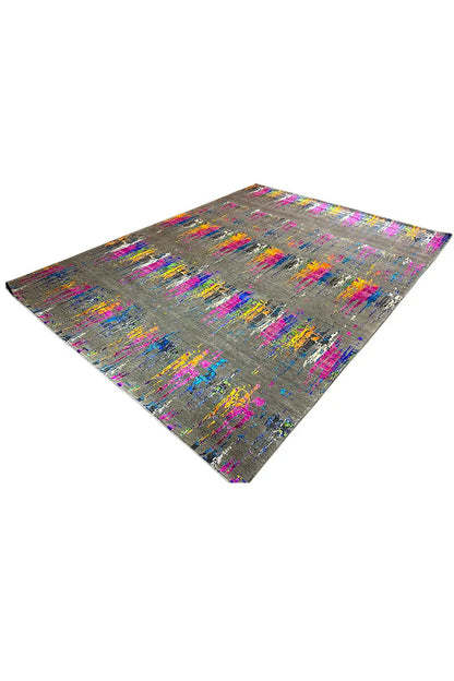 Designer rug placed at an angle: abstract pattern in bright colors on gray fabric.