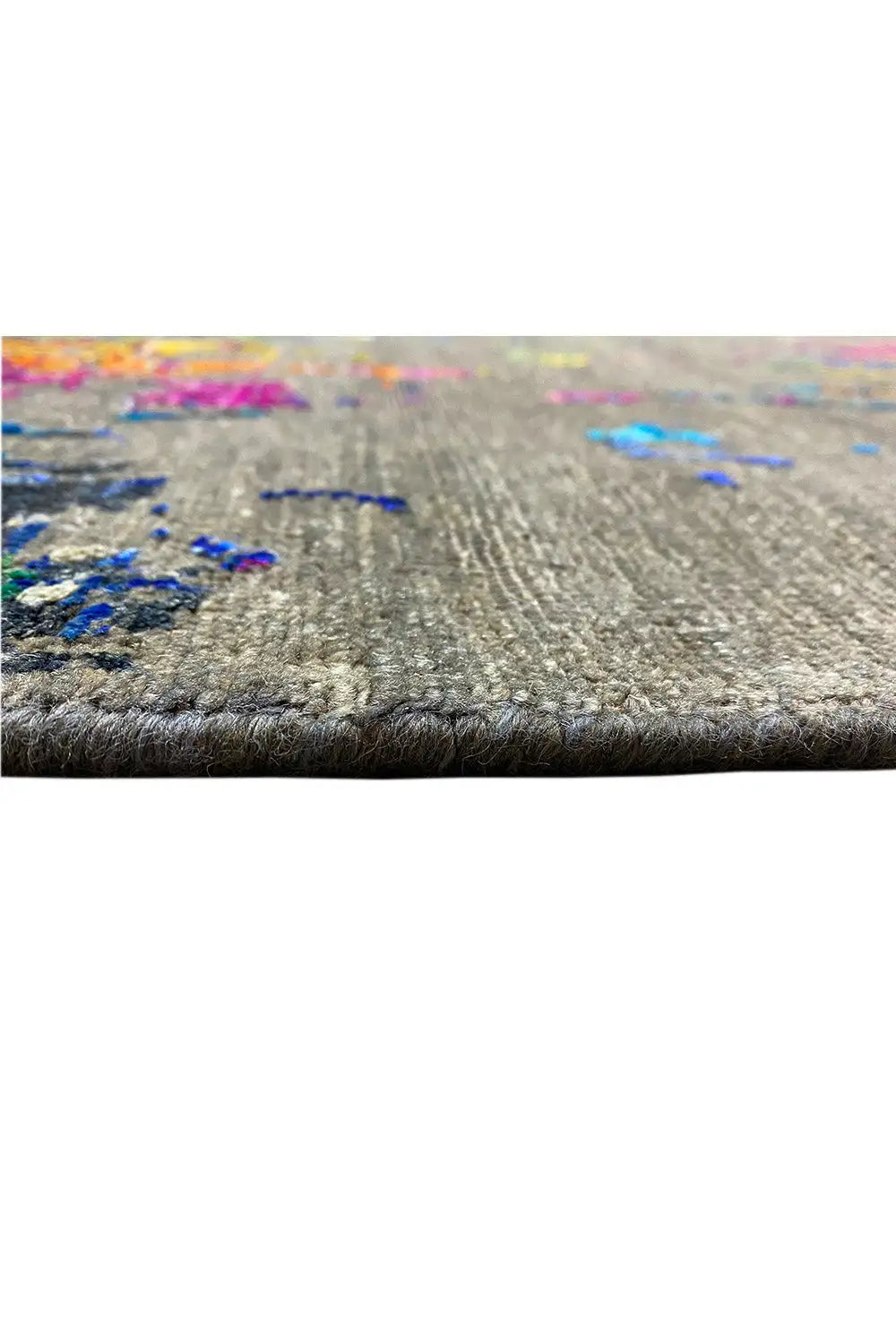 Carpet edge in detail: gray woven texture with a colorful pattern and visible edge stitching.