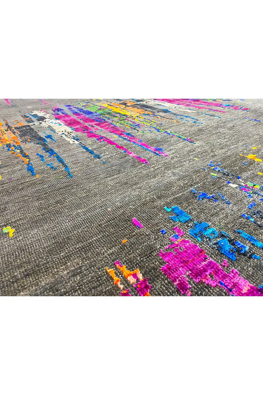 Close-up of the carpet pattern: magenta, blue, and orange accents on a gray background.