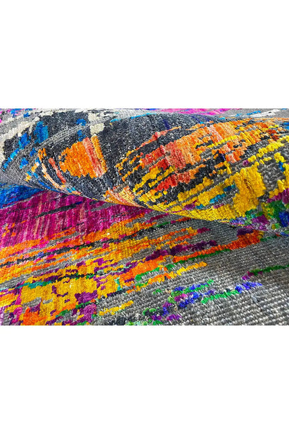 Carpet detail with multicolored, wave-like patterned areas (orange, yellow, blue, pink) on gray.