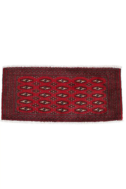 Rectangular Turkmen carpet, red with a central field pattern and white fringes along the edge
