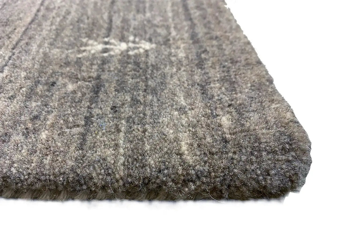 Rug corner with short, mottled pile in gray and beige; solid-colored edge.