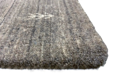 Rug corner with short, mottled pile in gray and beige; solid-colored edge.