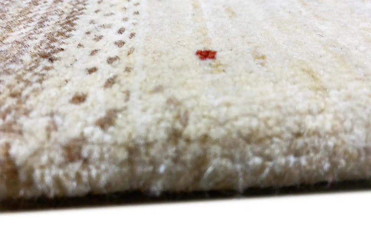 Close-up of Lori Gabbeh rug: soft pile texture in light beige with a brown contrasting border