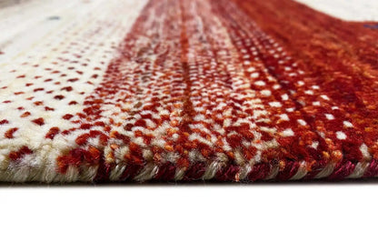Gabbeh rug close-up: short fringe along the edge, red and cream-colored pile texture