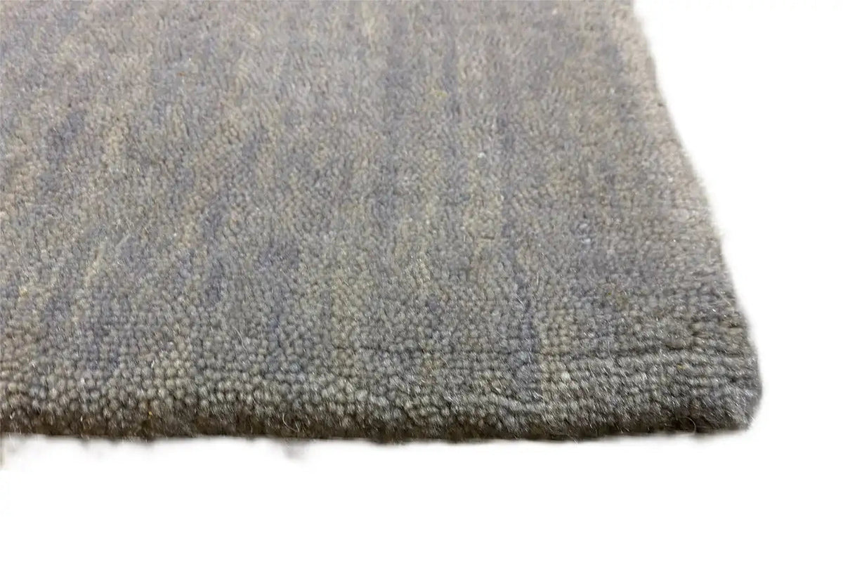 Gabbeh rug, light gray mottled, high pile with woven edge, edge view