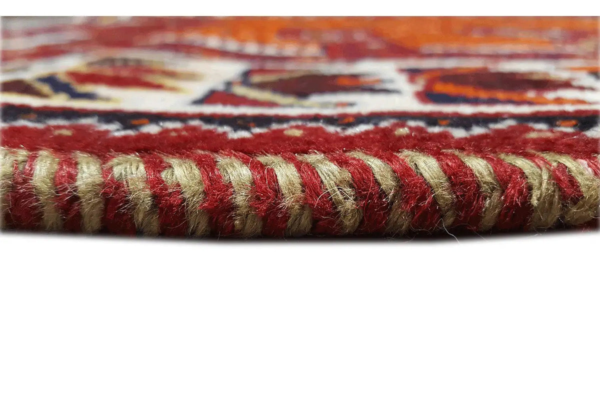 Rug edge with fringe trim, patterned border in red, cream, and dark blue
