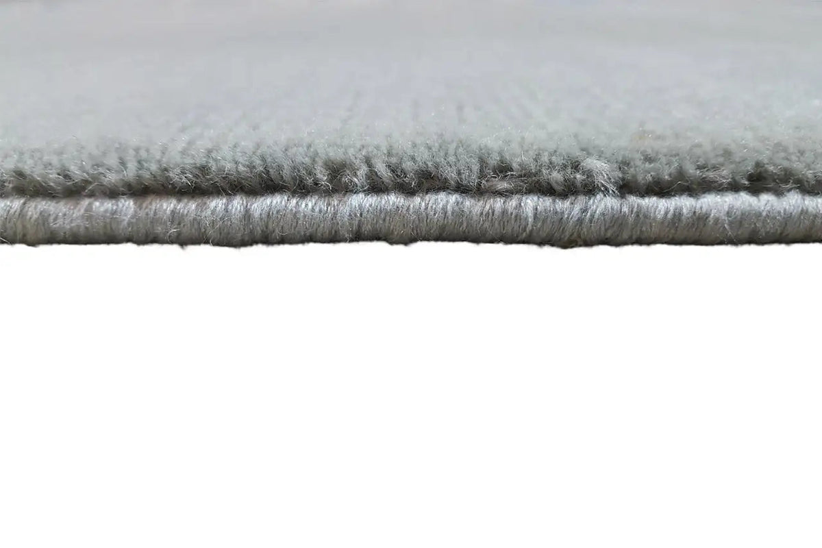 Carpet edge with short, gray pile and a visible seam along the edge.