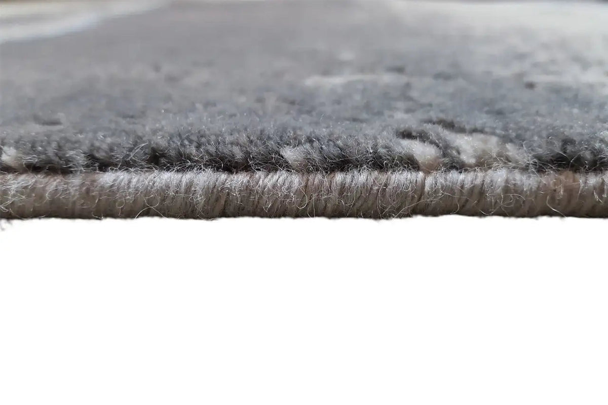 Beach rug - Flores detail: dense gray rug with a visible blue edge.