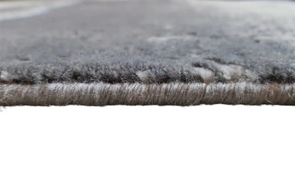 Beach rug - Flores detail: dense gray rug with a visible blue edge.