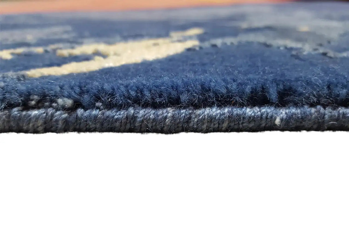 Rug pile in detail: dense, blue-gray pile along the edge of the colorful design