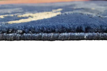 Rug pile in detail: dense, blue-gray pile along the edge of the colorful design