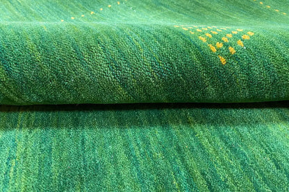 Green Gabbeh rug, close-up of the fine woven texture with light-colored flecks