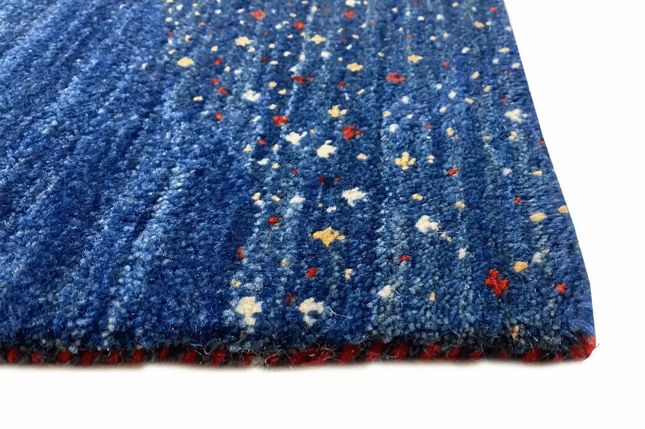 Carpet pile in vivid blue with colorful patches and a jagged edge