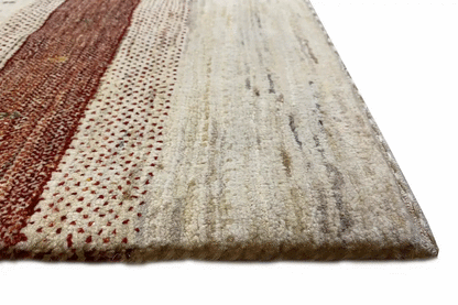 Close-up of Gabbeh rug: burgundy border area and cream-colored pile