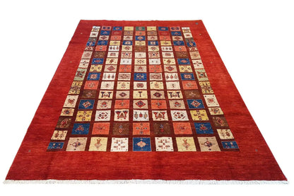 Rug with a red border and a square patchwork pattern in blue, beige, and red