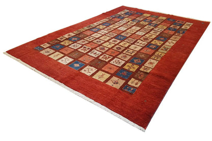 Rug with a red base, multicolored patchwork pattern, and light-colored bound edge
