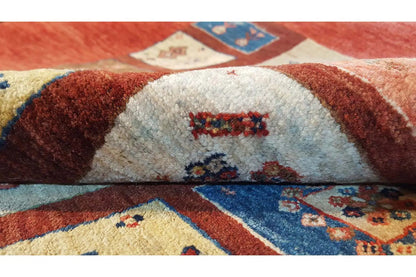 Carpet detail with embroidered motif panels in red, blue, and beige, centered