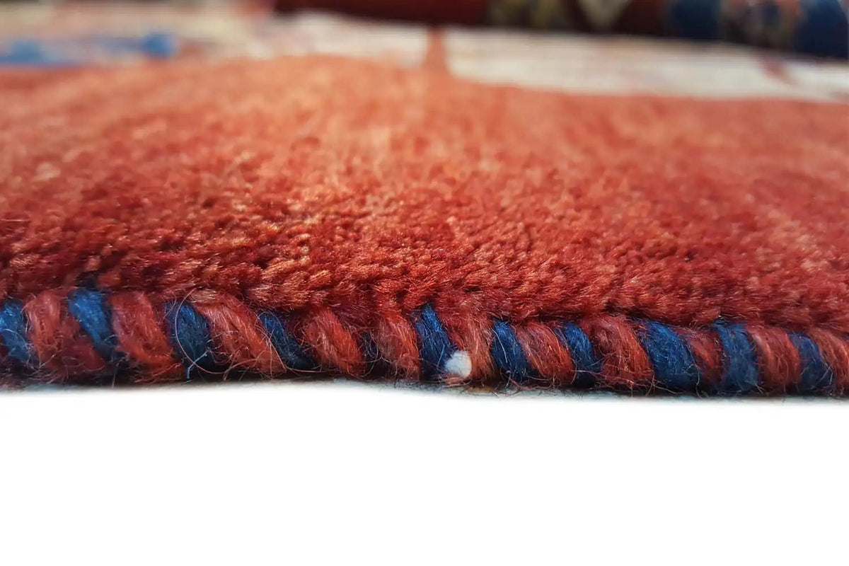 Carpet edge with a multicolored border and short fringe wrapping along the edge